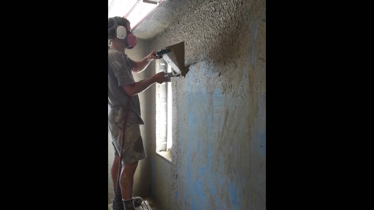 Using a sprayer to apply earthen plaster brown coat over Durisol blocks ...