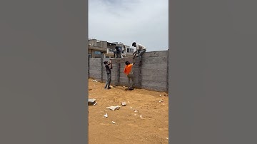 The readymade compound boundary fins are inserted by the labour in the top like this#compoundwall