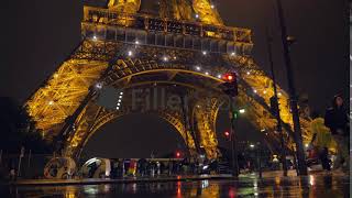 View to the street near illuminated Eiffel Tower in Paris at rainy night, France