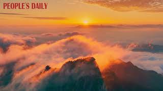The soft glow of sunrise painted the sea of clouds and majestic peaks in dreamlike hues in Luoyang. screenshot 2
