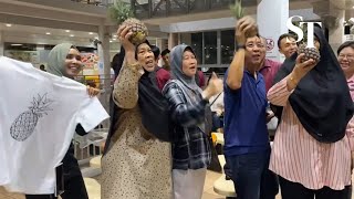 Tharman supporters arrive at Taman Jurong Food Centre with chants and pineapples