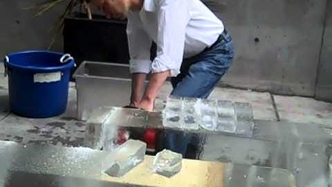 slicing off the big block of ice with a chainsaw