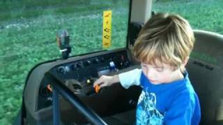 Farmer James driving John Deere tractor at harvest 2010