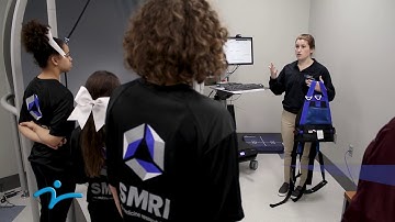 Morgan demonstrates the Bertec balance technology at SMRI to AWHI students