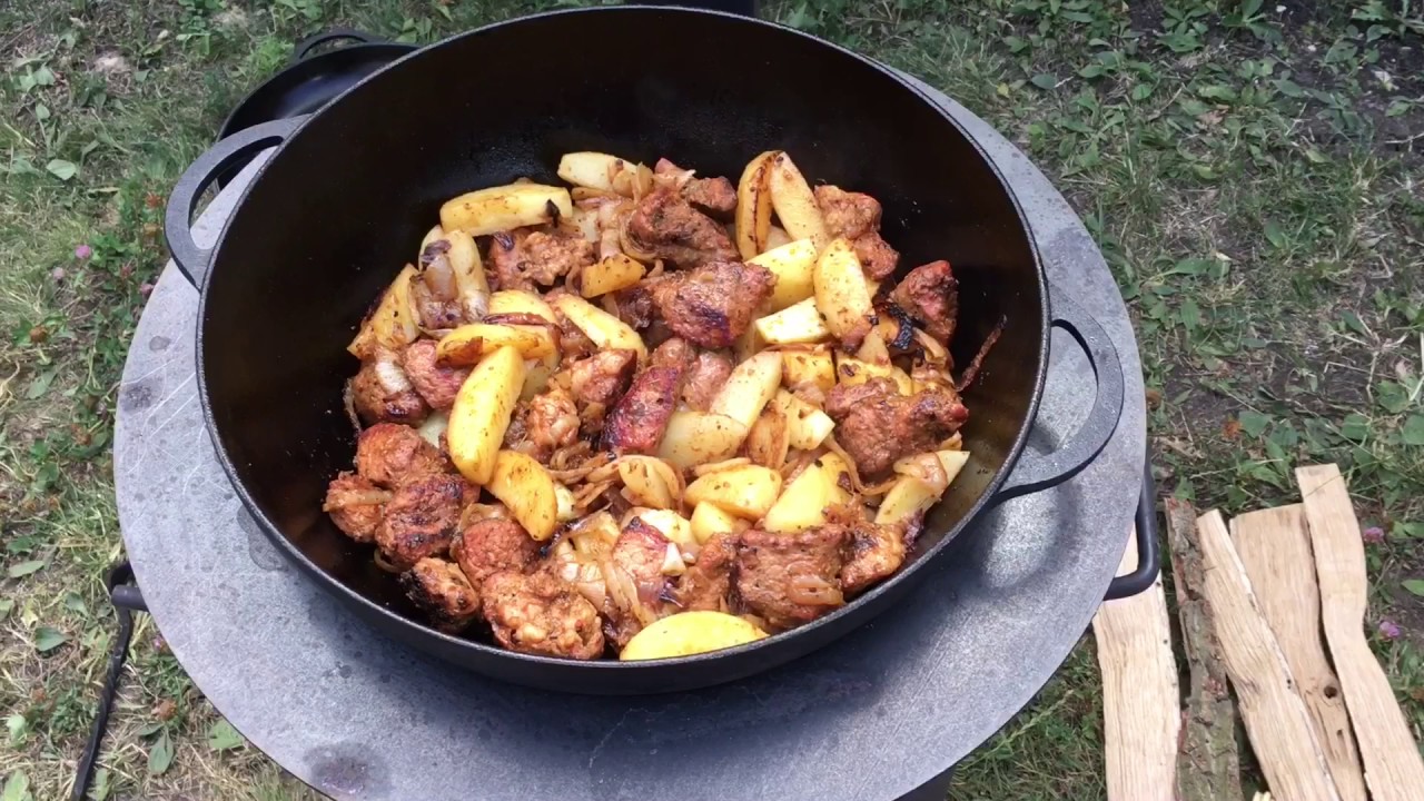 Свинина в казане на костре с картошкой. Жареная картошка с мясом и луком в казане. Картошка в казане на костре. Жаркое в казане с картошкой на костре. Картошка с мясом в казане на костре.