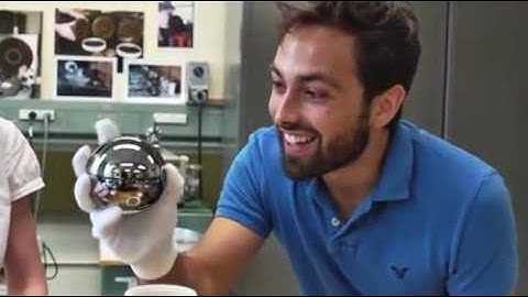 Man holds the roundest object in the world