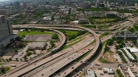 Aerial view of large multilane highway intersection in town. Cars smoothly driving in lanes through