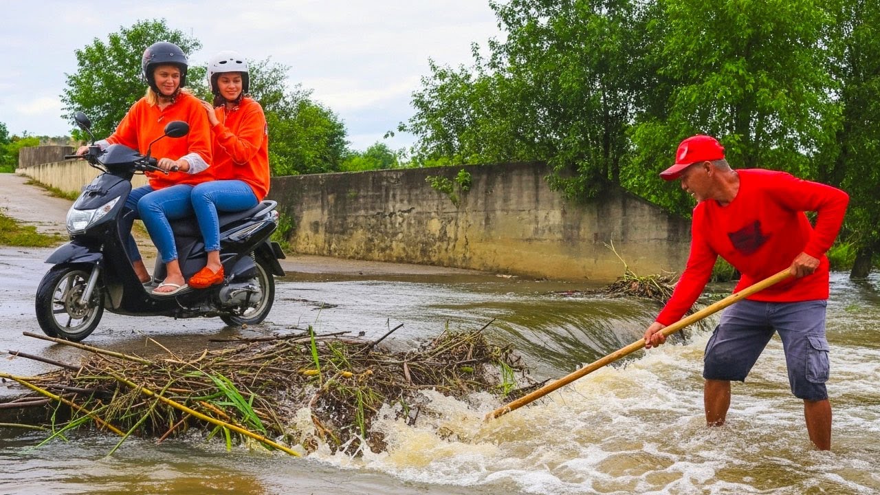 After Villagers Hard Crossing On Dam Drain Water While Almost Clogged By Branch Of Tree And Weed