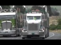 Kenworth log trucks passing a peterbilt
