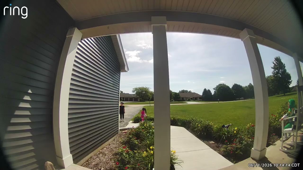 Boy wearing Green Power Rangers costume sits on rocking chair on porch and falls forwards onto grass