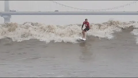 Surfers Ride Tidal Bores in East China's Qiantang River - DayDayNews