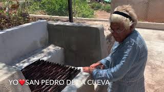 Doña Beba Feliz con su hornilla, lavadero, lavoteaste, puerta y casa pintada