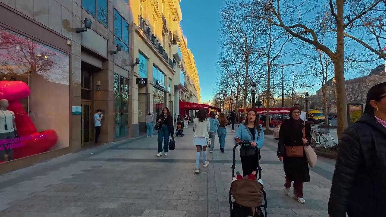 Walking tour Champs-Elysees on a spring day among a crowd of people of different nationalities