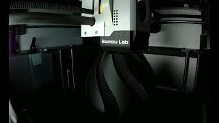 Bambu Labs X1C printing a full-size vase in charcoal black filament.