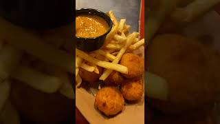 Linus Mac and Cheese Bites over French Fries, served with a Spicy Aioli