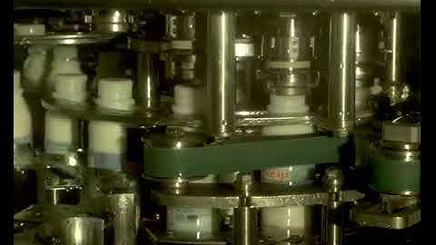 Manufacturing  automated bottle capping filmed in slow motion