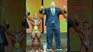 Strongman standing next to bodybuilders
