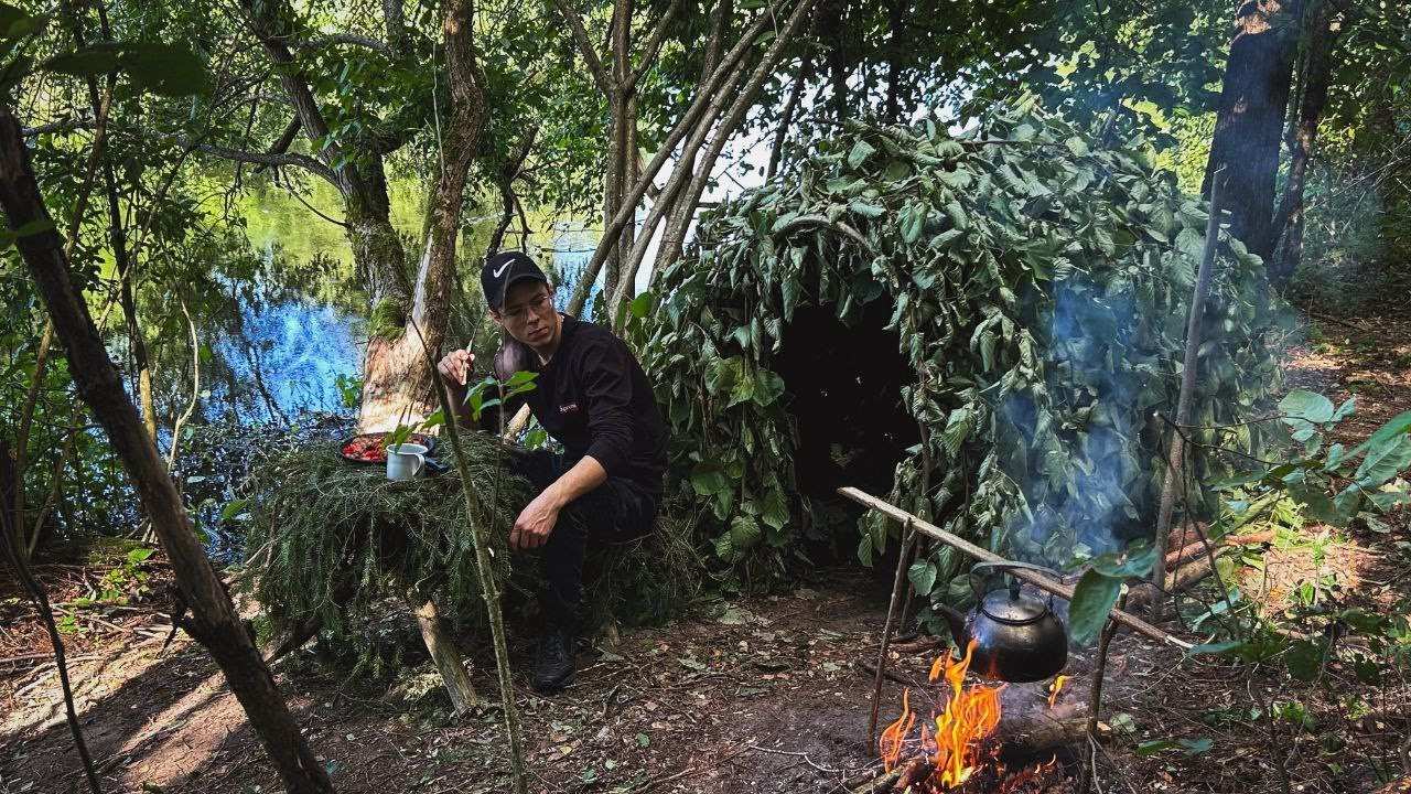 Bushcraft camping by the river.Building a cozy shelter.Cooking on coals ...