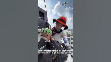 Female technician installing air conditioner outdoor unit at height