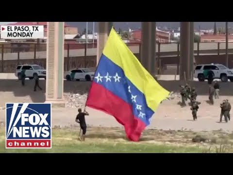 Migrants wave flag on US soil after illegally crossing border