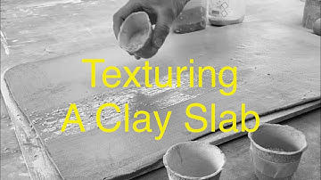 Using grog to add texture to a clay slab.