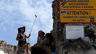 Tourists enjoying Mykonos sun aware of Greek hosts dark clouds