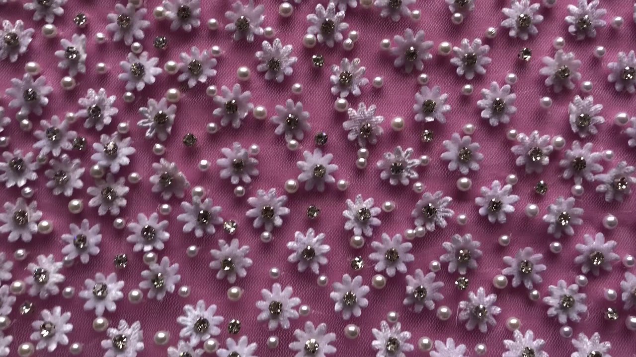 An ivory lace with a dense array of small, embellished flowers