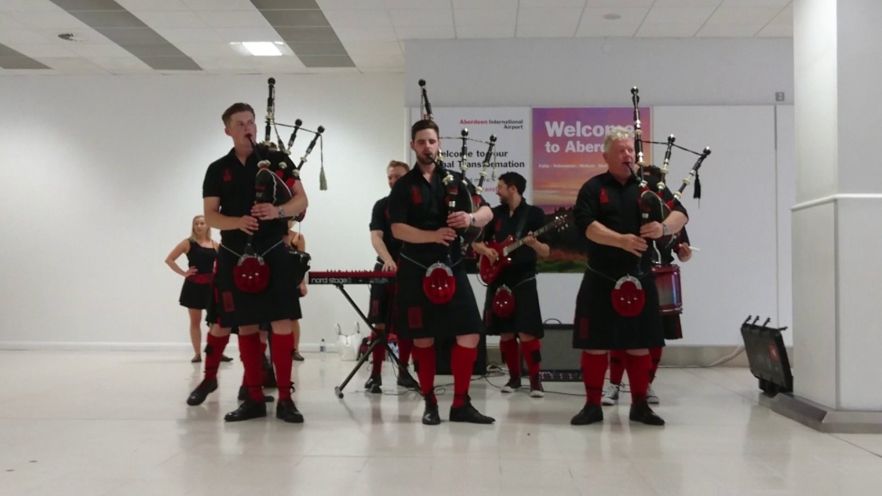 Red Hot Chilli Pipers Performing At Aberdeen Airport Chasing Cars By red-hot-chilli-pipers-performing-at-aberdeen-airport-chasing-cars-by