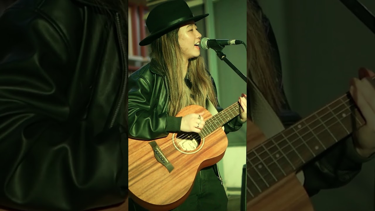 Singer-songwriter sing cover of a popular song with her acoustic guitar