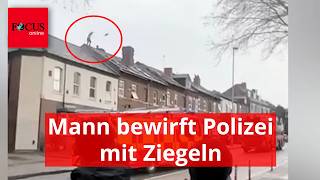 Man climbs onto roof and throws bricks at police