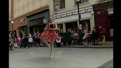 A ballet dancer in ethnic dress dancing in the street.