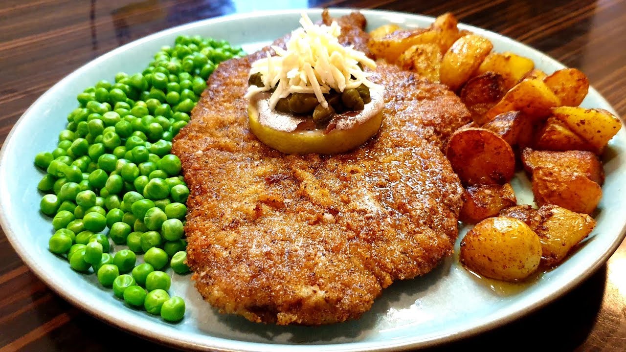 Wienerschnitzel med dreng, brasede kartofler, ærter og smørsovs.