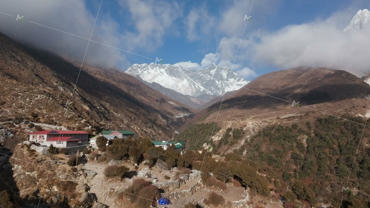 Skyward shot of a serene Nepali hamlet, showcasing alpine homes and grand snowy ridges