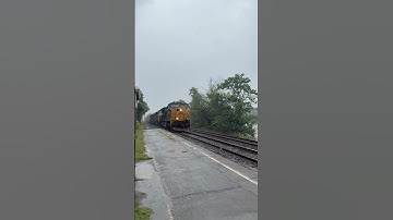 CSX intermodal with track geometry boxcar at speed in the rain