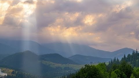 Sun Rays Pass through the Clouds Over the Mountains at Sunset | Stock Footage - Videohive