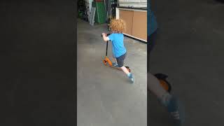 Alex riding his hot wheels scooter.