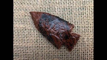 191- Flint knapping a chunk of red/black obsidian into a point.1/2
