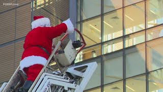 Santa greets patients at Yale New Haven Children's Hospital from aerial ladder