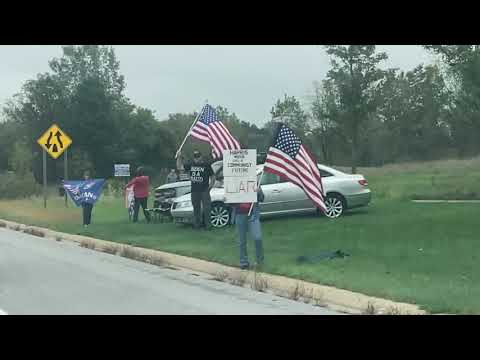 Protestors line streets in advance of President Biden visit to Howell, Michigan