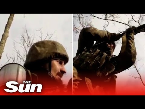 Ukrainian fighter sips coffee while he fires machine gun at Russian forces