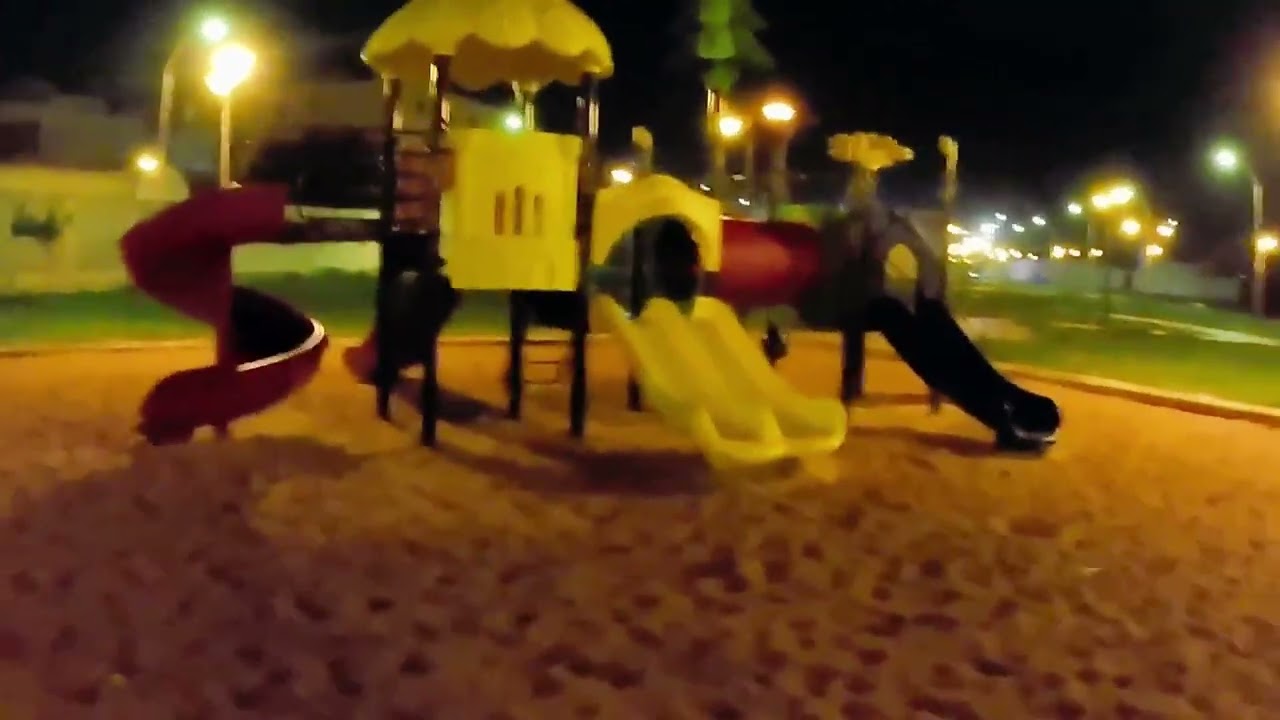 حديقة عامة ليلًا – أضواء ومساحات خضراء