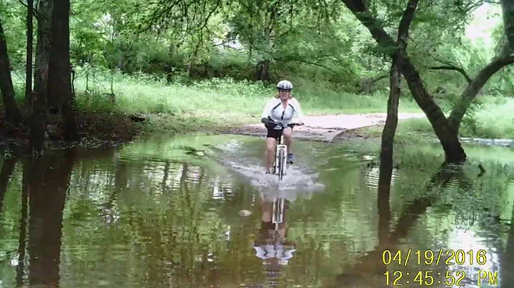 Deb crossing creek on mountain bike