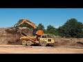 Hitachi 225 excavator at work loading tipper trucks