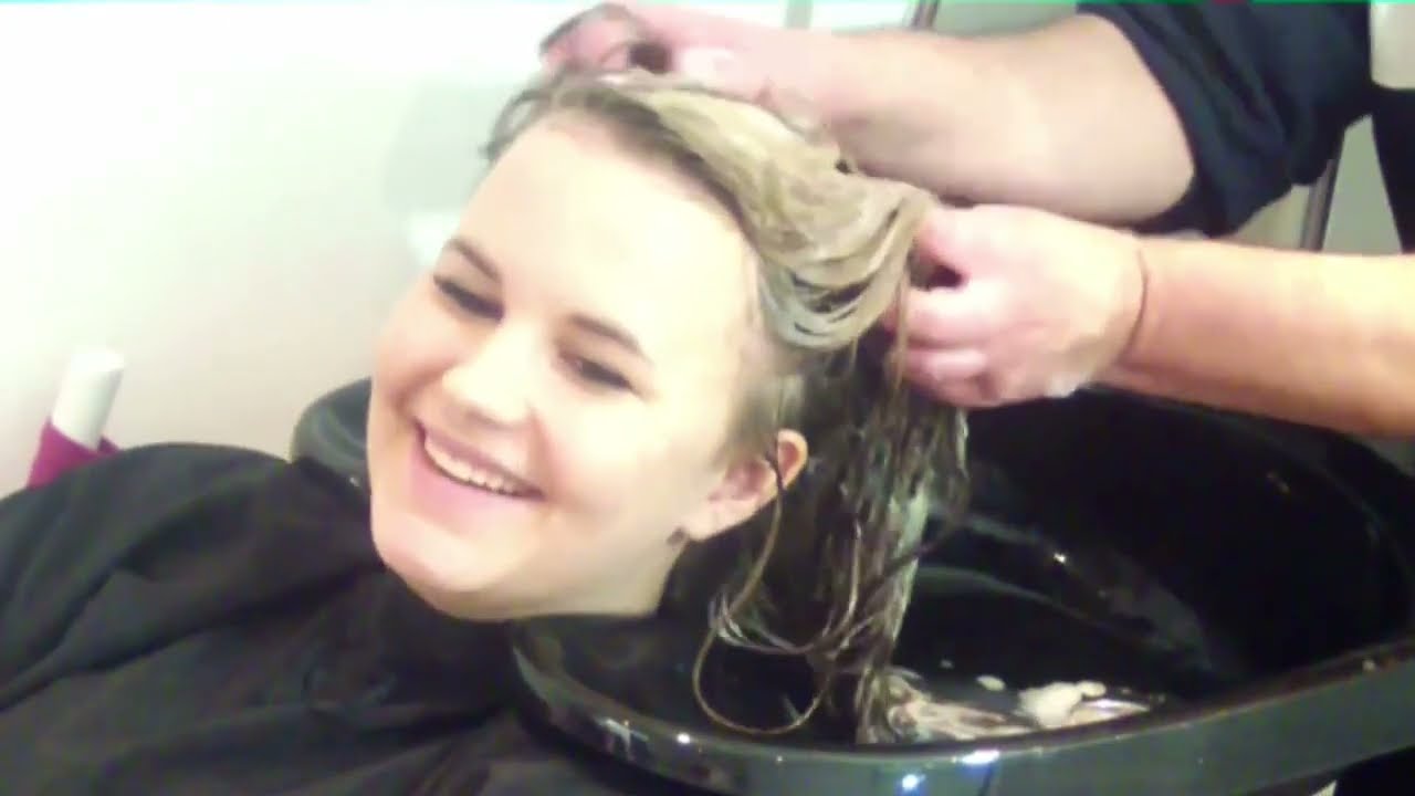Two beautiful blondies with long hair receiving shampoo