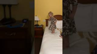 Girl jumps from bed to bed in hotel room but misses a step and falls off