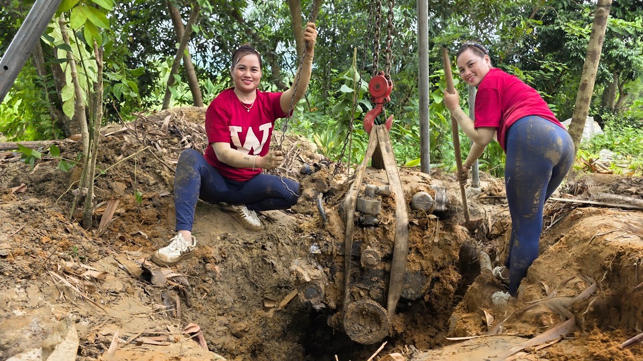 The girl repaired and restarted the engine of the car rusted and abandoned for a long time.