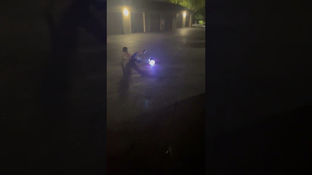 Boy rides hoverboard in parking lot then falls and lands on his rear