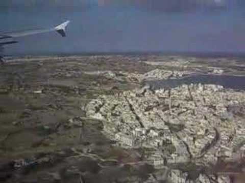 Landing at Malta International Airport flying over Marsaxlokk Bay, Malta Freeport and the village of Birzebbuga.