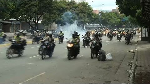 Police on motorbikes chase down protesters in Caracas