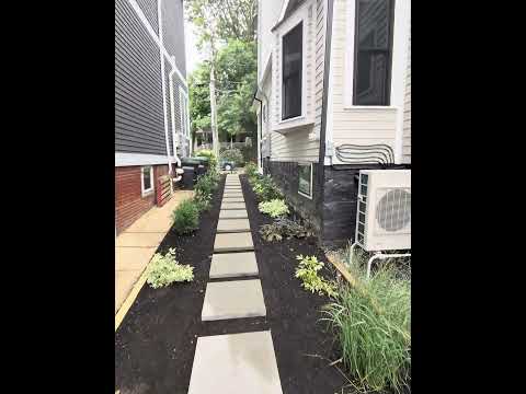 Finished permeable paver driveway with new curb cut, back patio, and native planting in Somerville MA